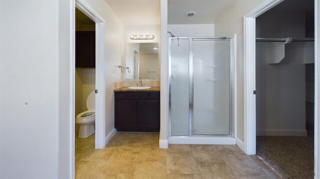 bathroom featuring walk in shower, tile patterned floors, vanity, and toilet