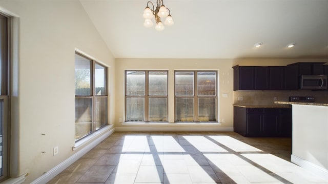 kitchen featuring an inviting chandelier, lofted ceiling, backsplash, and light tile patterned floors