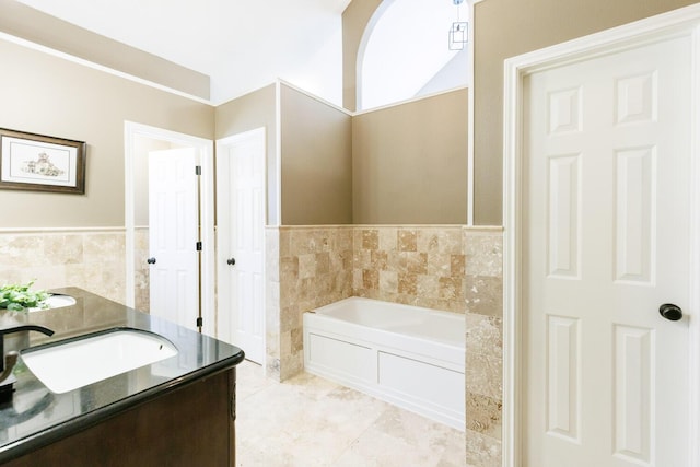 3709 156th St, Lubbock, TX 79423 - full bath featuring a garden tub, vanity, tile walls, wainscoting, and tile patterned floors