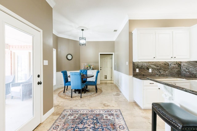 3709 156th St, Lubbock, TX 79423 - kitchen with white cabinets, crown molding, hanging light fixtures, wainscoting, and dark stone counters