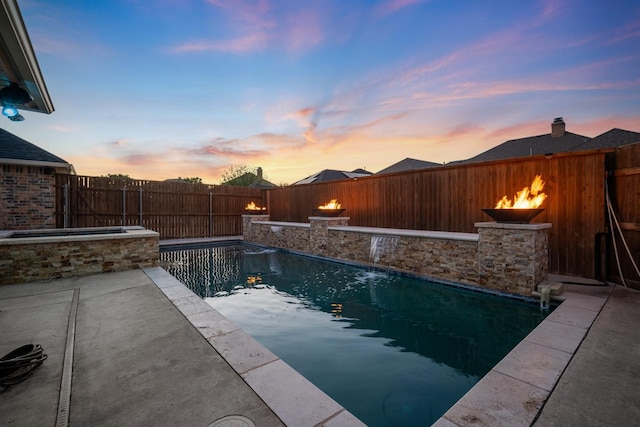 pool at dusk featuring pool water feature