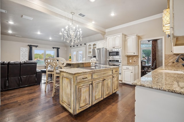 kitchen featuring pendant lighting, sink, appliances with stainless steel finishes, dark hardwood / wood-style floors, and an island with sink