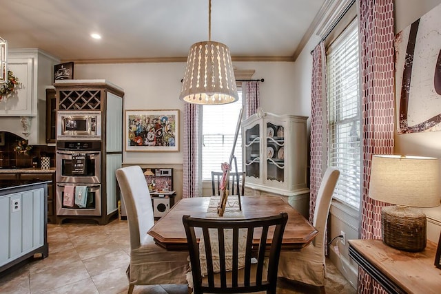 dining room featuring an inviting chandelier, light tile patterned flooring, and crown molding