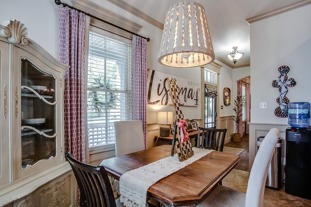 dining room featuring a wainscoted wall, a wealth of natural light, and crown molding