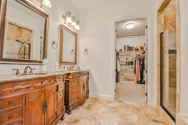 full bath with double vanity, a stall shower, baseboards, tile patterned floors, and a spacious closet