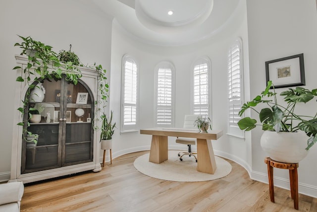 office space with ornamental molding, light wood-type flooring, and baseboards