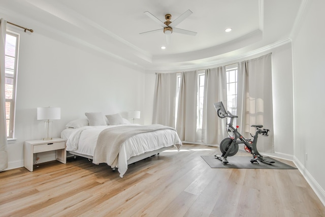 bedroom with baseboards, a raised ceiling, ornamental molding, wood finished floors, and recessed lighting