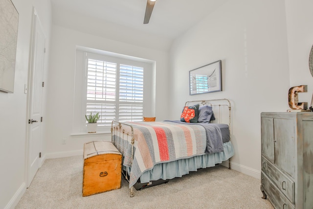 carpeted bedroom featuring lofted ceiling, baseboards, and a ceiling fan