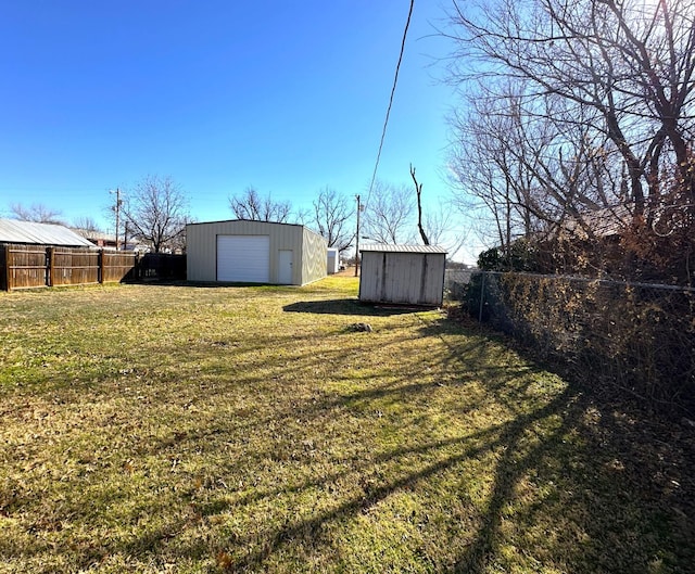 view of yard with a garage and an outbuilding