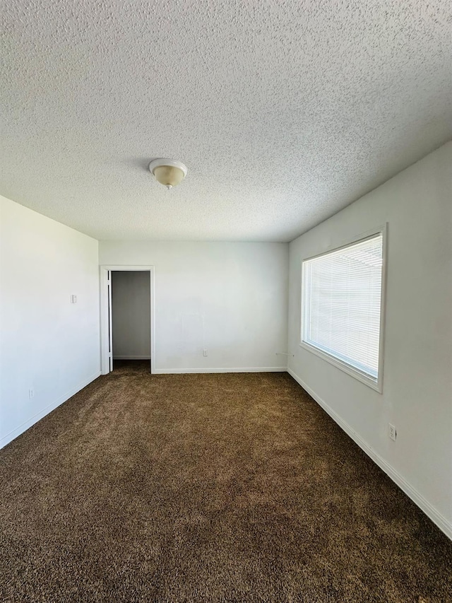 carpeted empty room with a textured ceiling