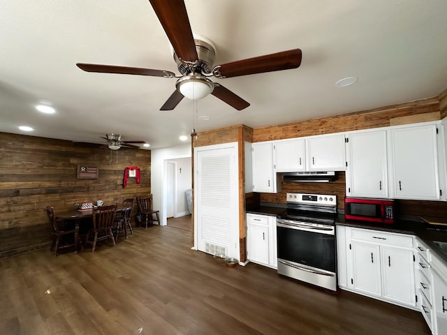 kitchen featuring tasteful backsplash, white cabinets, dark hardwood / wood-style flooring, stainless steel electric stove, and wood walls