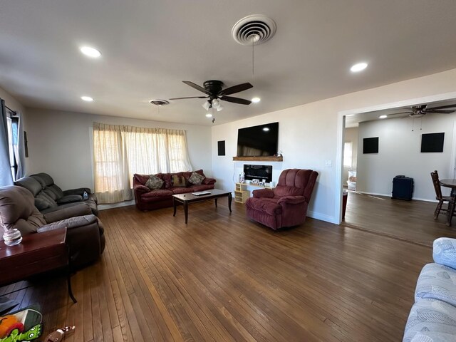 living room with dark hardwood / wood-style flooring and ceiling fan