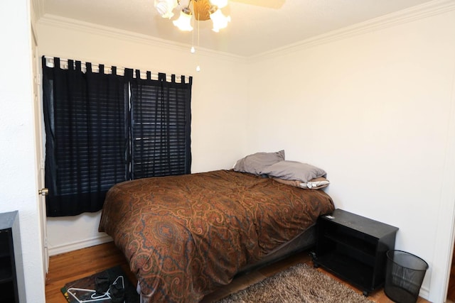 bedroom featuring hardwood / wood-style flooring, ornamental molding, and ceiling fan