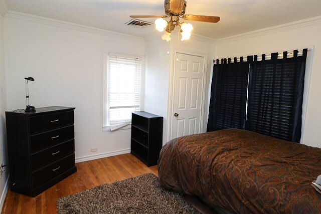 bedroom with ornamental molding, ceiling fan, and light wood-type flooring