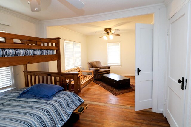 bedroom with hardwood / wood-style flooring, crown molding, and ceiling fan