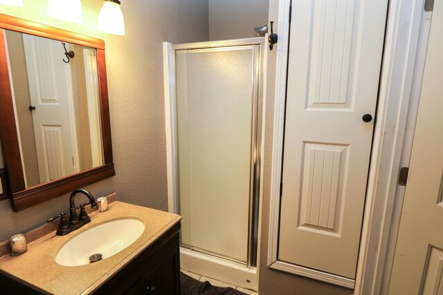 bathroom featuring vanity and a shower with shower door