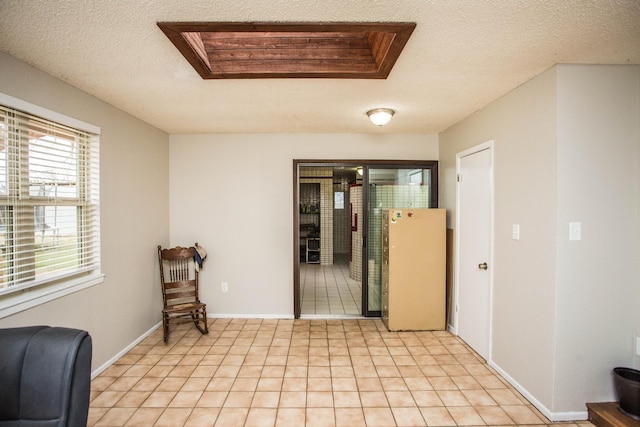sitting room featuring baseboards, visible vents, light tile patterned floors, and a textured ceiling