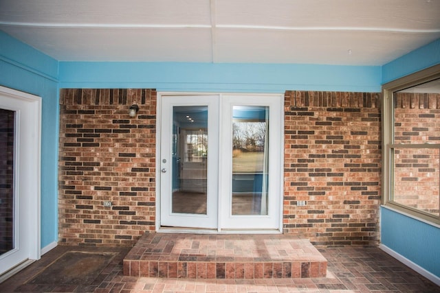 entrance to property featuring brick siding