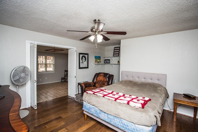 bedroom with a ceiling fan, a textured ceiling, baseboards, and wood finished floors