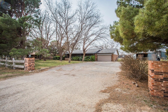view of front of property featuring fence and a garage
