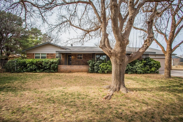 ranch-style home featuring a front lawn, driveway, a porch, and an attached garage
