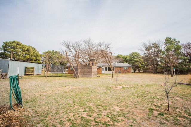 view of yard featuring an outbuilding and a trampoline