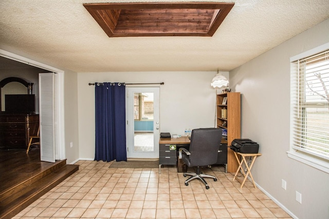 office area featuring light tile patterned flooring, a textured ceiling, and baseboards