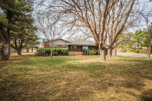 view of yard featuring covered porch and fence