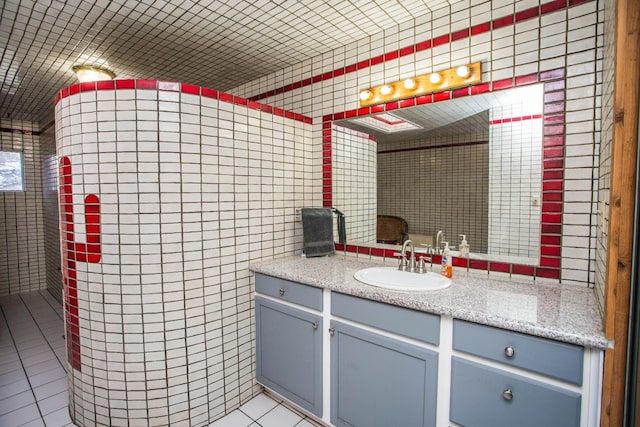 bathroom with tile patterned floors, vanity, and tile walls