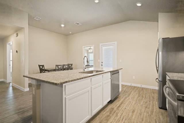 kitchen featuring sink, white cabinetry, stove, a center island with sink, and stainless steel dishwasher