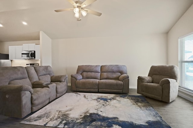 living room with ceiling fan, lofted ceiling, and dark hardwood / wood-style flooring