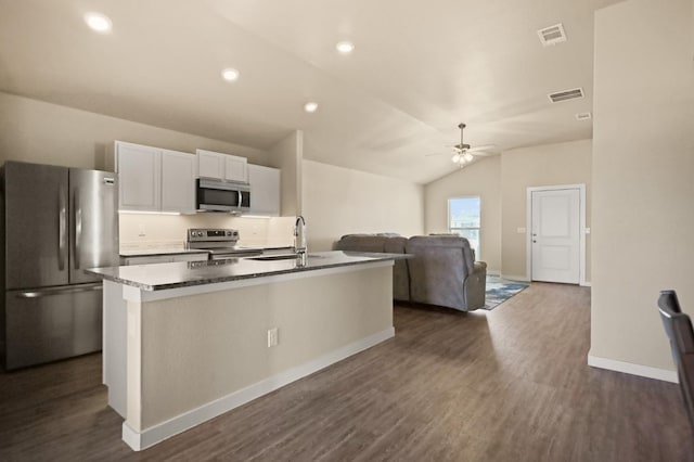 kitchen featuring sink, dark wood-type flooring, appliances with stainless steel finishes, white cabinetry, and a center island with sink