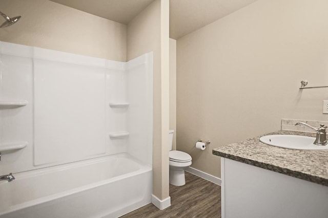 full bathroom with hardwood / wood-style flooring, vanity, bathing tub / shower combination, and toilet