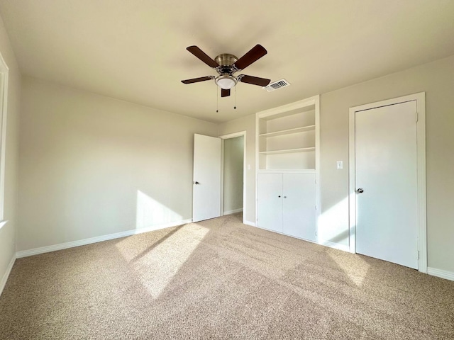 unfurnished bedroom with ceiling fan, carpet, visible vents, and baseboards