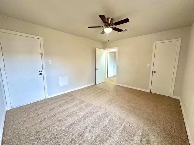 carpeted empty room featuring a ceiling fan, visible vents, and baseboards