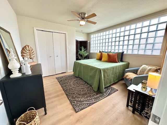 bedroom with ceiling fan, a closet, and wood finished floors