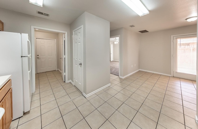 kitchen featuring white refrigerator, light tile patterned floors, and ceiling fan