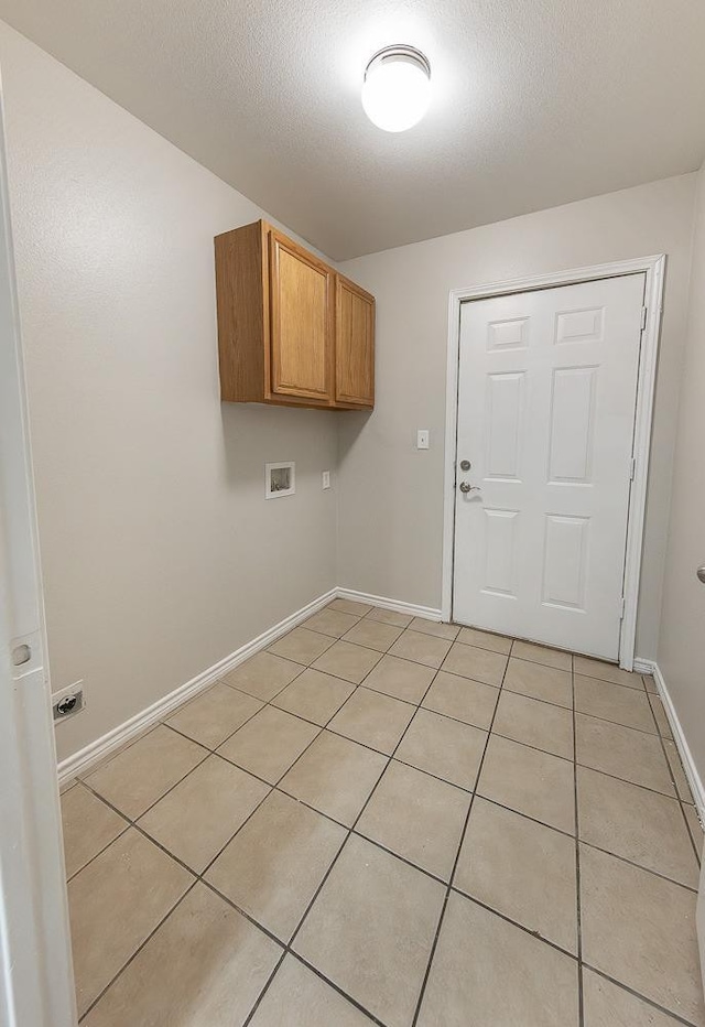 laundry area with cabinets, hookup for a washing machine, a textured ceiling, and light tile patterned floors