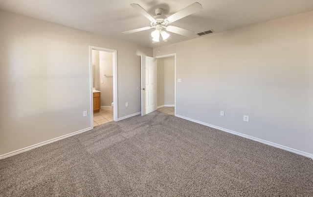 unfurnished bedroom with connected bathroom, light colored carpet, and ceiling fan