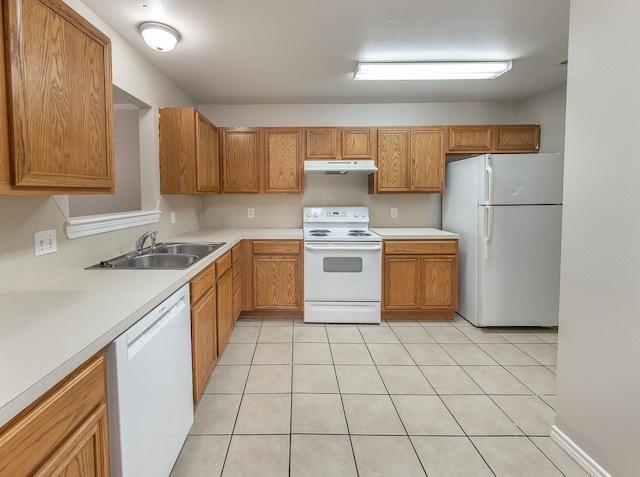 kitchen with sink, light tile patterned floors, a textured ceiling, and white appliances