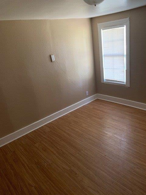 empty room with dark hardwood / wood-style flooring