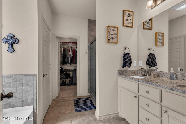 7116 23rd St, Lubbock, TX 79407 - full bathroom with vanity, a shower stall, a spacious closet, and a garden tub