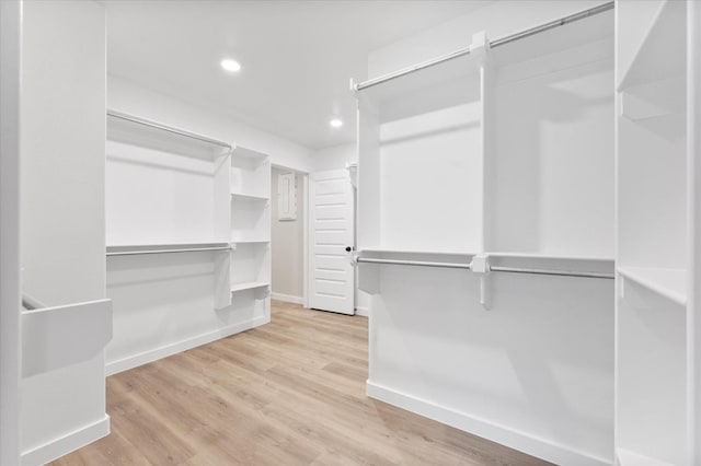 walk in closet with light hardwood / wood-style floors