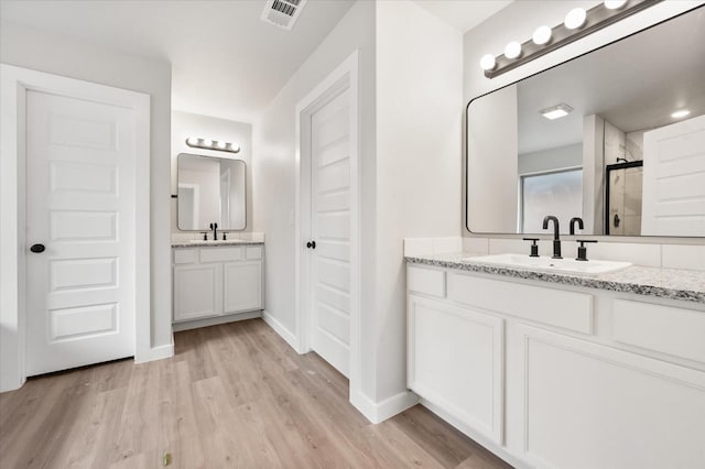 bathroom featuring vanity, hardwood / wood-style flooring, and walk in shower