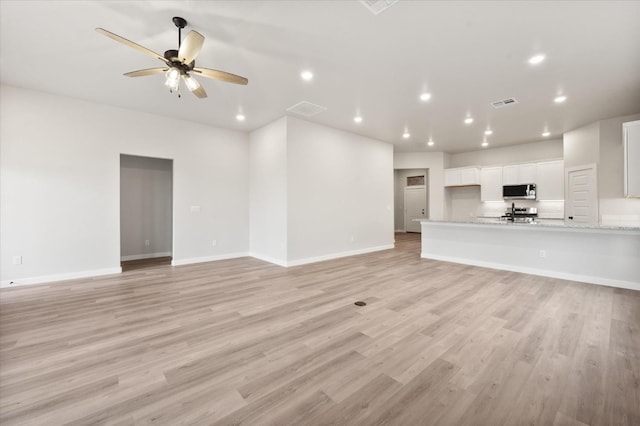 unfurnished living room with ceiling fan and light hardwood / wood-style flooring