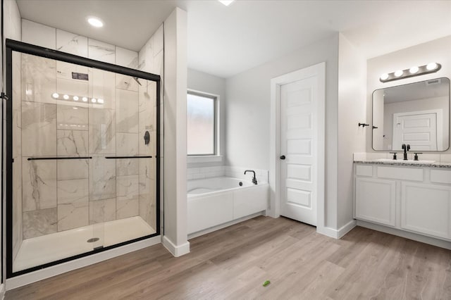 bathroom featuring vanity, separate shower and tub, and hardwood / wood-style floors