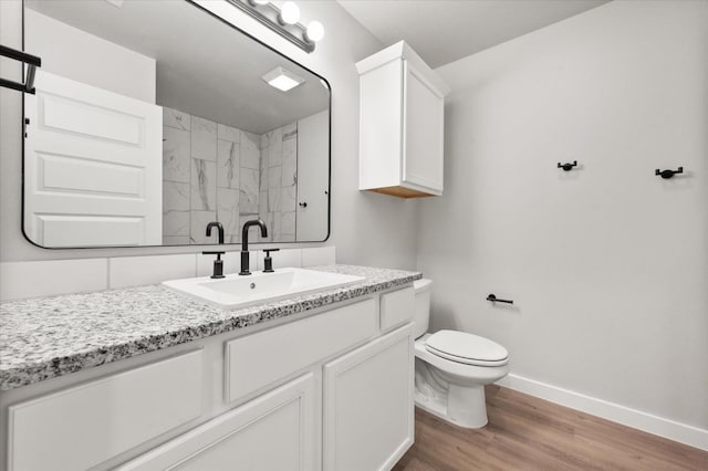 bathroom with vanity, toilet, hardwood / wood-style floors, and walk in shower