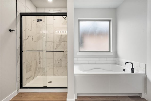 bathroom with plus walk in shower and wood-type flooring