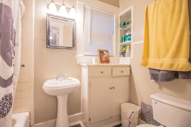 bathroom featuring shower / bathtub combination with curtain and toilet