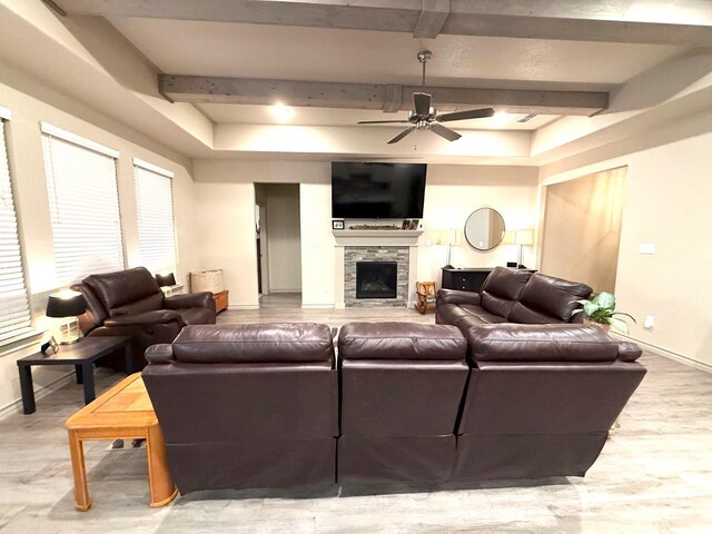 living room featuring beamed ceiling, ceiling fan, a fireplace, and hardwood / wood-style floors